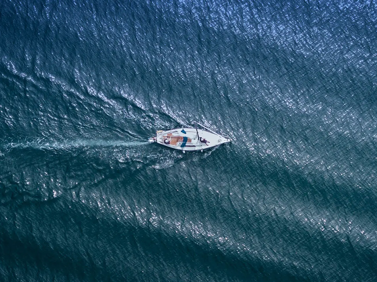 Overhead view of a sailboat sailing from left to right